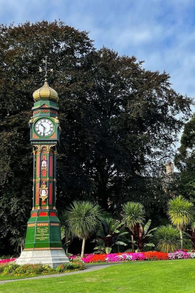 Colorful flower beds and blooming plants at Borough Gardens with visitors enjoying the serene environment.