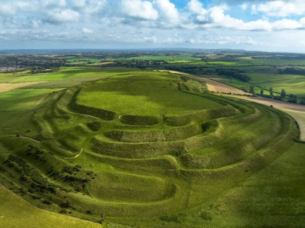 The vast, rolling landscape of Maiden Castle with its ancient hill fort and walking paths.